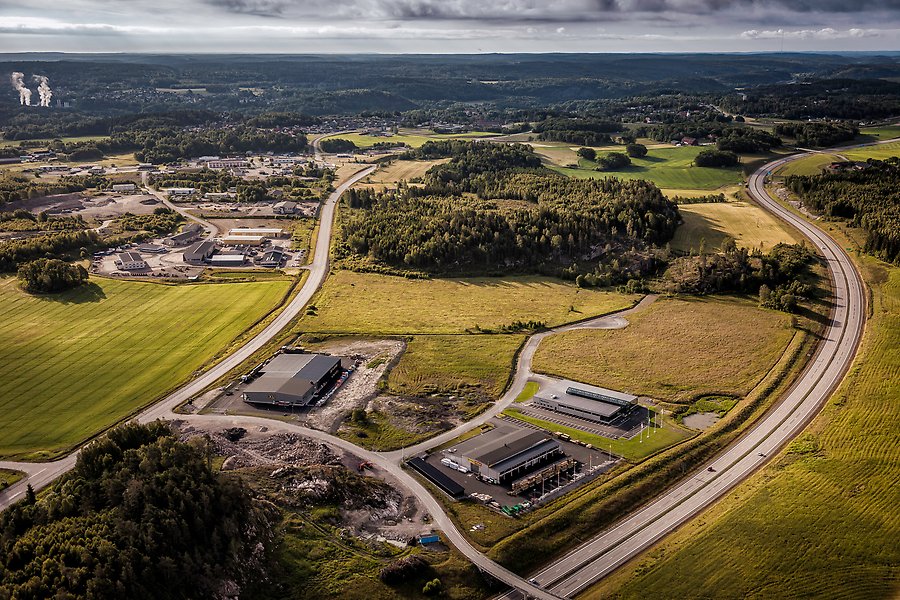Flygbild över Säleby industriområde med E6:an till höger och Munkeland längre bort i bild. Närmast syns jordbrukslandskap med industritomter mellan två vägar. Längre bort syns bostadsområde och skog.