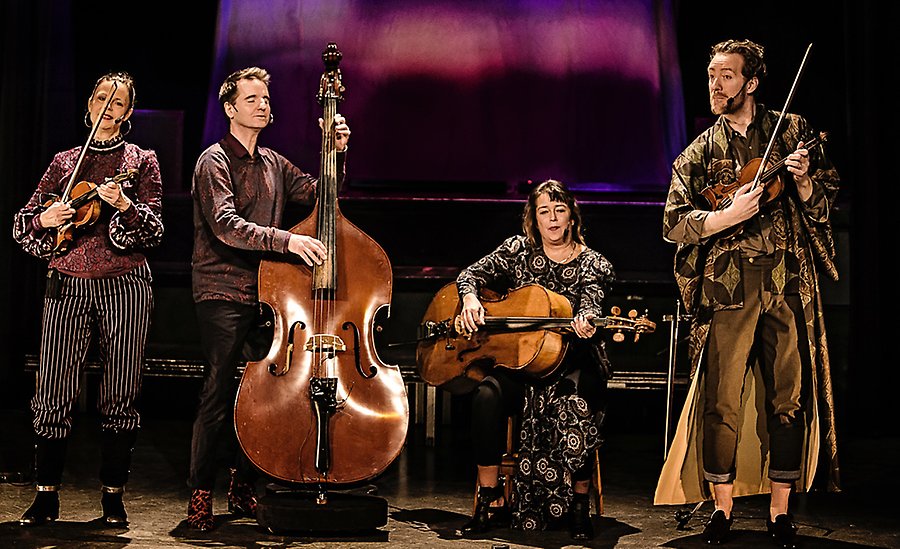 Fyra personer på en scen som spelar olika sträng- och stråkinstrument: bland annat fiol och cello.