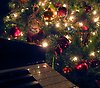 Foto på ett piano och en julgran med röda kulor samt en g-klav i guld.