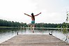 Flicka som hoppar från en brygga i en sjö.