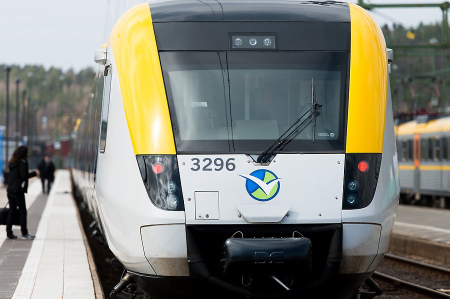 Bild på loket på ett modernt tåg som går i grått och gult. Tåget står vi Munkedals järnvägsstation.