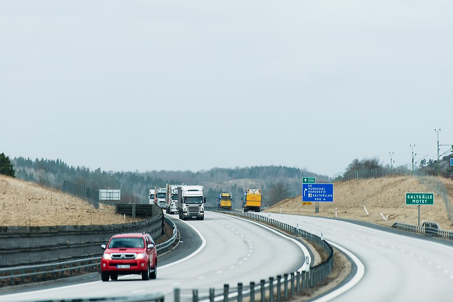Foto på en motorväg med bilar och långtradare.