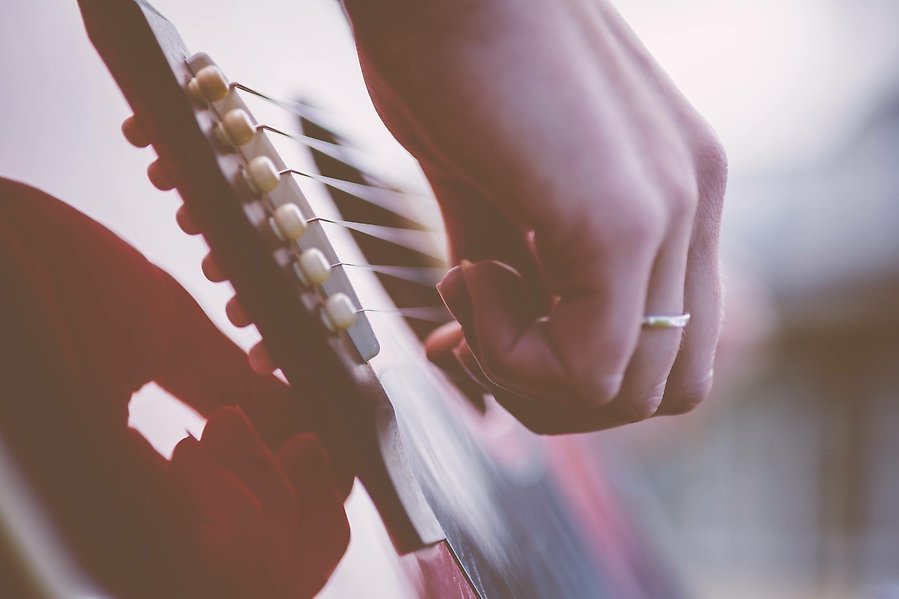 Närbild på en hand som spelar på en gitarr.