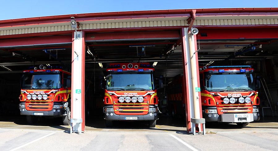 Bild på tre brandbilar uppställda i räddningstjänstens garage