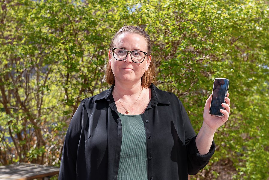 Person som håller upp en mobiltelefon