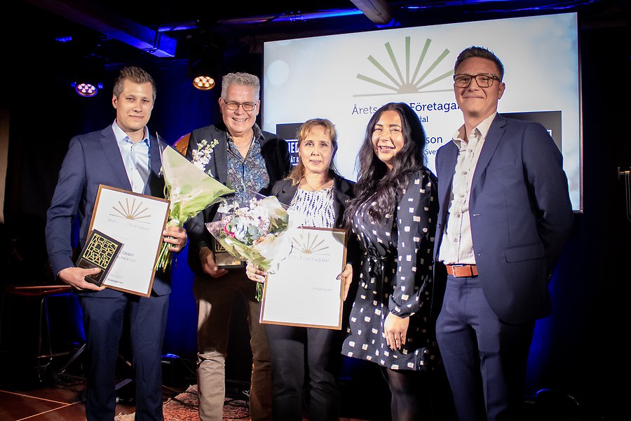 Flera personer uppställda för gruppfoto, varav några personer håller upp blommor och prisdiplom.