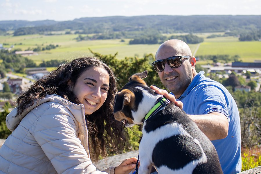 Två personer leker med en hund