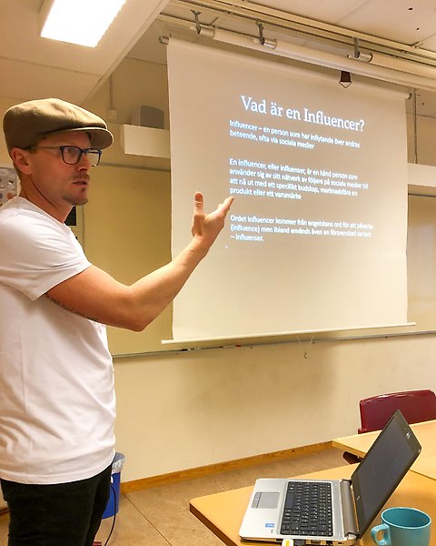 Person med keps och glasögon som visar en bildpresentation